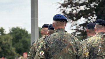 Soldaten stehen um das Hochkreuz Rückenaufnahme